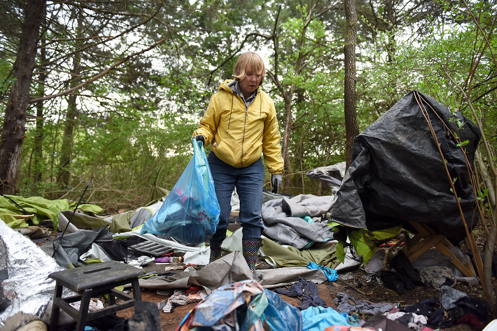 Flo Osborn works to clean up a homeless campsite